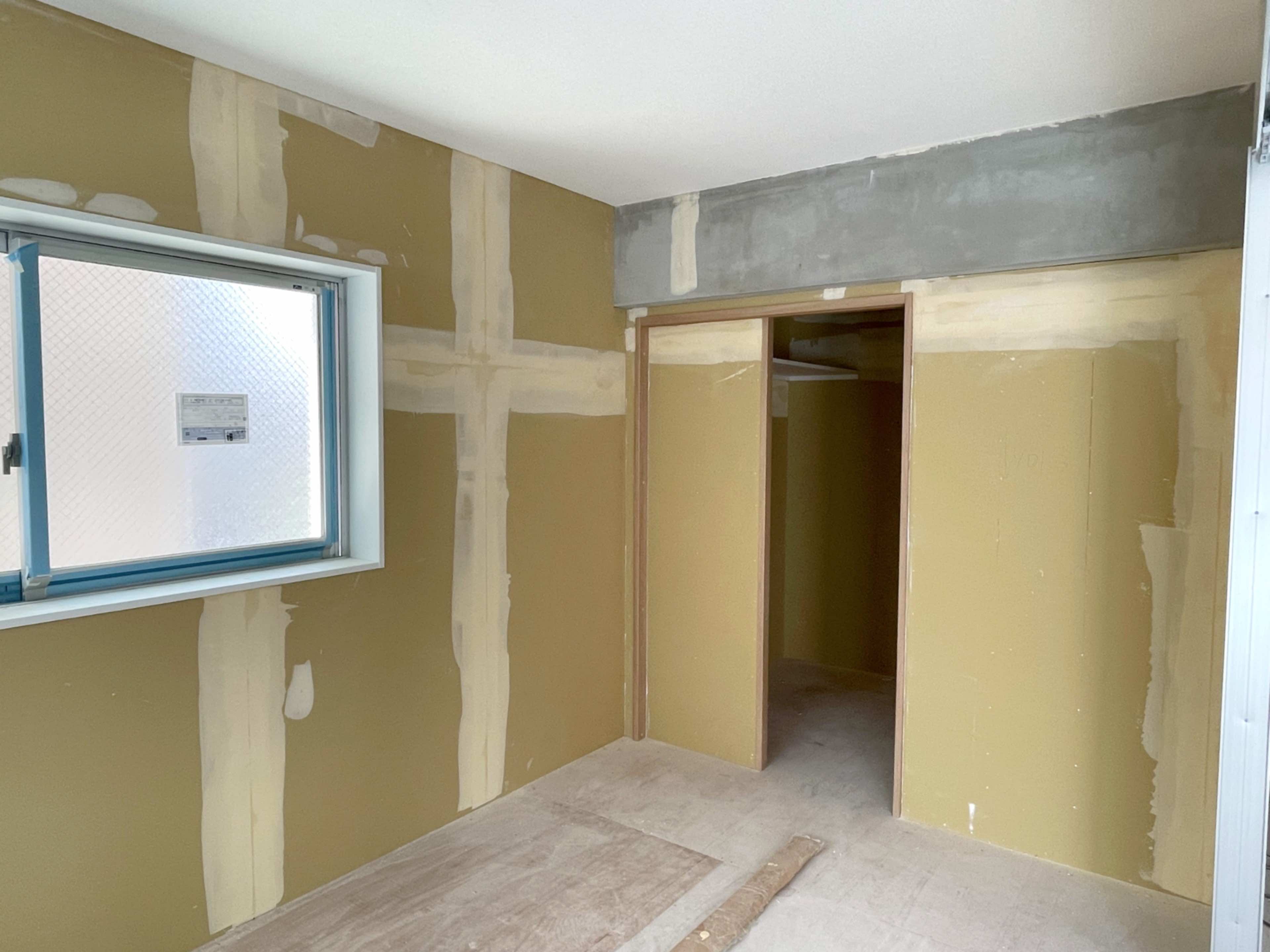 ドア枠が取り付けられた建築途中の室内で、仕上げ前の状態